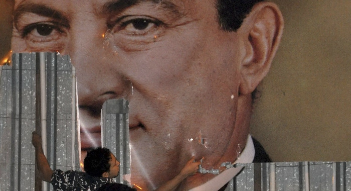 An anti-government protester defaces a picture of President Hosni Mubarak in Alexandria, Egypt, Jan. 25, 2011. Stringer/Egypt/Reuters/Corbis