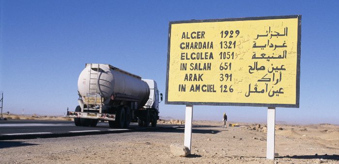 Truck passing road sign in Tamanrasset, Algeria. Frans Lemmens/Corbis