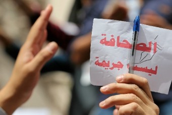 Journalist holding a sign, ''Journalism is not a crime'', during a protest at the Press Syndicate in Cairo, May 4, 2016. Reuters/Staff