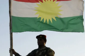 A Kurdish peshmerga soldier holds a Kurdistan flag in the northern Iraq, Ninawa province, Aug. 6, 2012. Azad Lashkari/Reuters