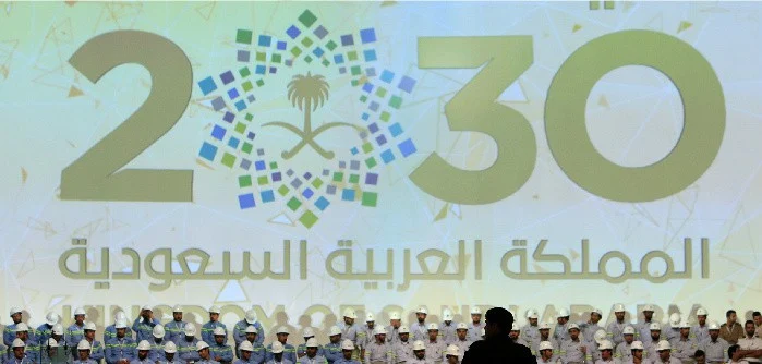 Large banner shows Saudi Vision for 2030 as a soldier stands guard at the inauguration of several energy projects in Ras Al Khair, Saudi Arabia. Nov. 29, 2016. Zuhair Al-Traifi/Reuters