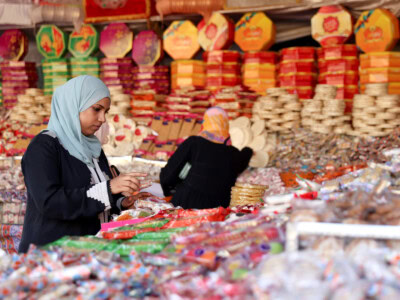 A woman buys traditional handmade sweets at a street market ahead of Mawlid al-Nabi, the birthday of Prophet Mohammad, in Sayeda Zainab neighbourhood in Cairo, Egypt, as sellers and customers all say prices of raw materials have increased due to the currency crisis, leading to a decrease in demand, September 24, 2023. REUTERS/Mohamed Abd El Ghany