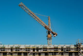 A crane extends over scaffolding of a construction project.